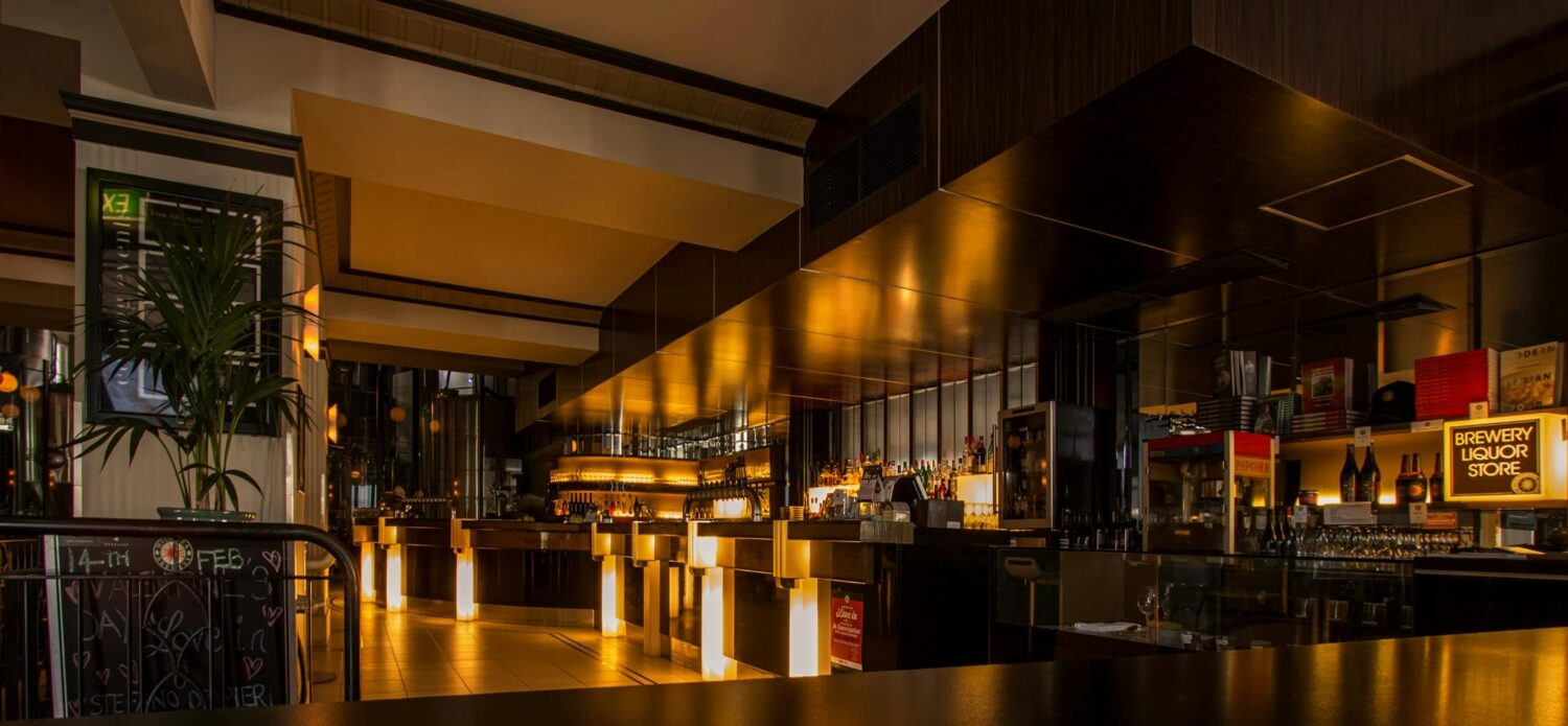 Stylish modern restaurant interior with warm lighting, elegant design, and luxurious ambiance at night.